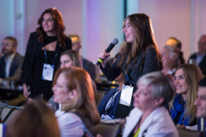 Student attendee speaking from audience during an event.