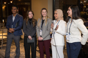 Group of student attendees speaking in a line.