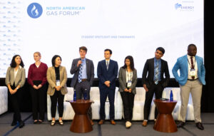 Line of student attendees standing on stager and speaking to audience.