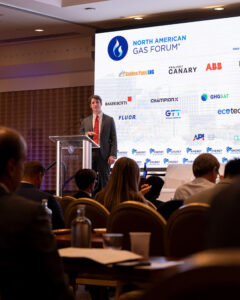 Student speaker standing at podium on stage and speaking to audience.