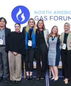 Energy Dialogue employees standing on stage with students.