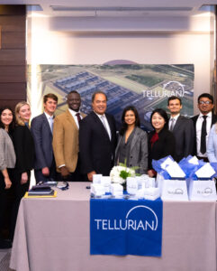 Business owners with students standing at table.